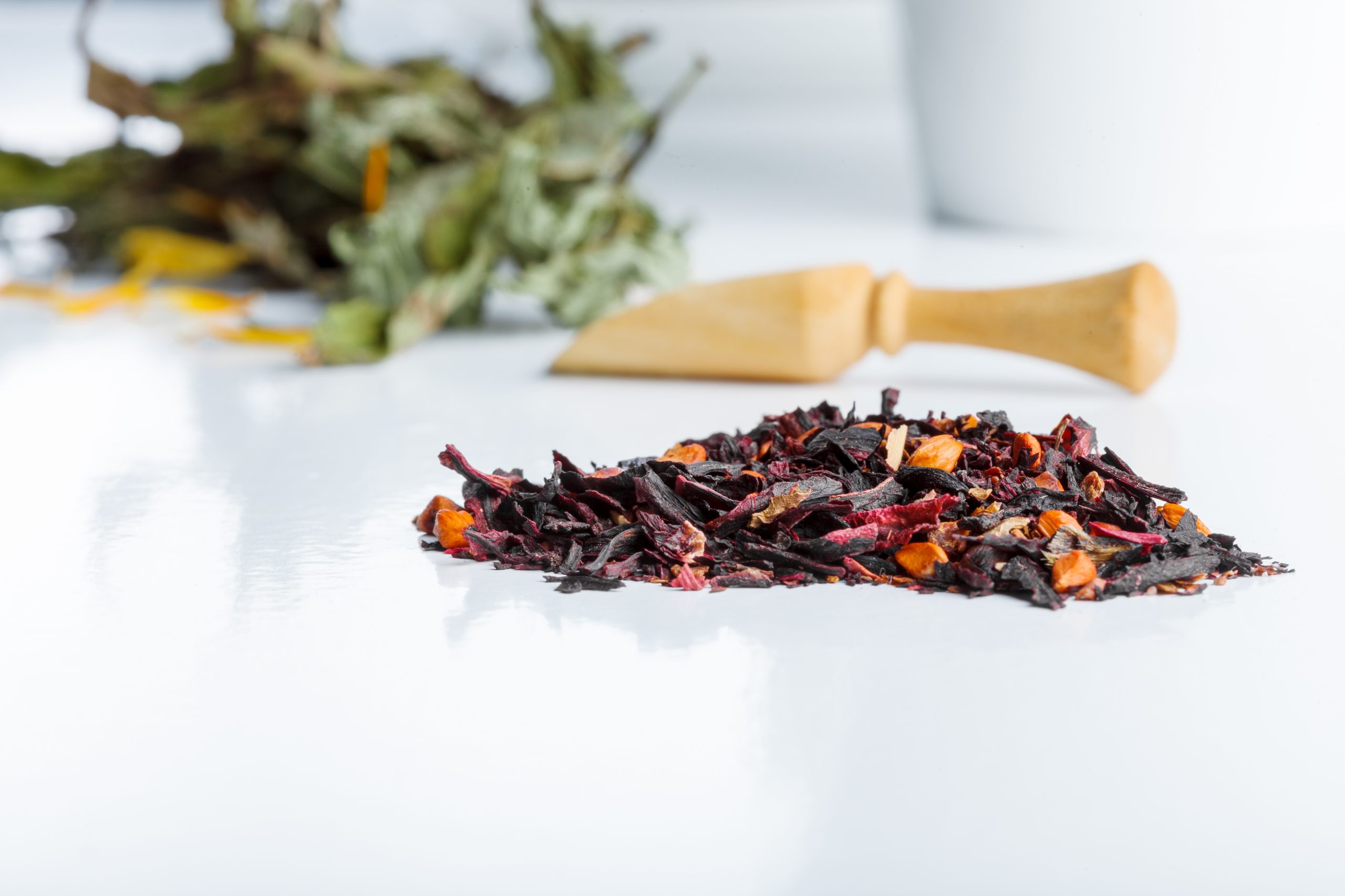 Asian aromatic tea ingredients and herbs isolated on white background with wooden spoon and ceramic bowl